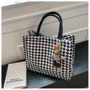 Detail of black and white houndstooth tote bag with a cute matching rabbit charm