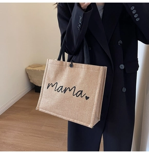 Close-up detail of the linen tote bag with mama print and secure black button closure