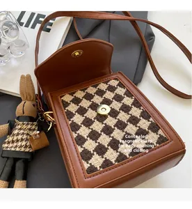 Detail of crossbody bag showing the invisible magnetic closure and houndstooth texture
