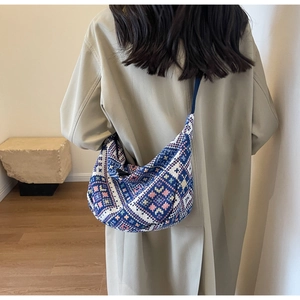 Detail of large ethnic canvas hobo bag with blue and white geometric patterns on model