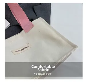 Détail de la texture en toile crème et des poignées roses du sac cabas de mode