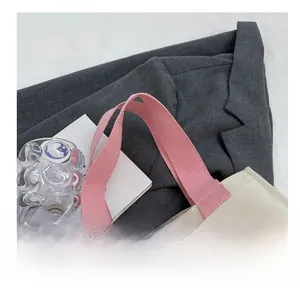 Gros plan d'un sac cabas en toile avec poignées en tissu rose et étiquette de mode