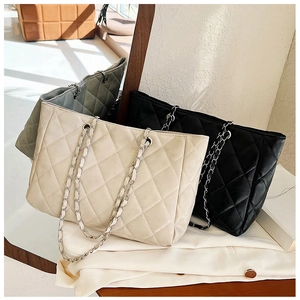 Detailed view of quilted leather tote bags with silver chain straps in multiple colors