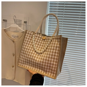 Detail of houndstooth tote bag featuring pearl chain and vintage wooden button closure