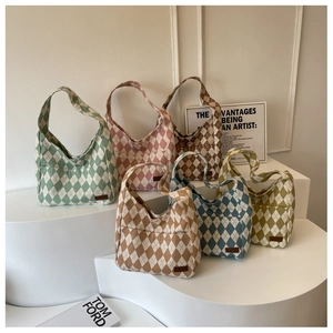 Multiple color options of quilted canvas hobo bags displayed on geometric stands