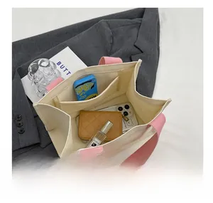 Détail de l'intérieur du sac en toile montrant plusieurs compartiments de rangement