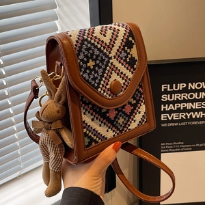 Ethnic style crossbody phone bag in dark brown faux leather with woven pattern and bunny charm