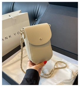 Detail der beigen Handytasche mit Ledermuster, Goldverschluss und Kettenriemen