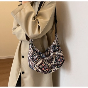 Ethnic geometric woven crescent bag shown on model with adjustable strap detail