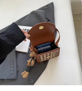 Detail of houndstooth crossbody bag interior showing space for two smartphones