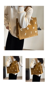 Detailed views of a mustard yellow canvas tote bag with bold white letter prints