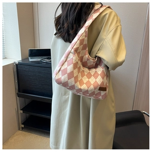 Detailed close-up of pink and white argyle canvas tote bag with leather brand patch