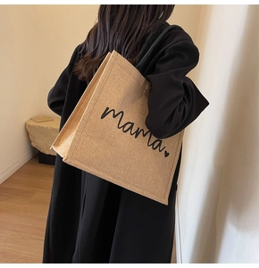 Detailed texture of the large jute tote bag with Mama print worn by a model