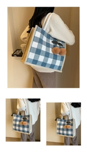 Detail of blue plaid linen tote bag with brown plush cherry charm and woven rope handles
