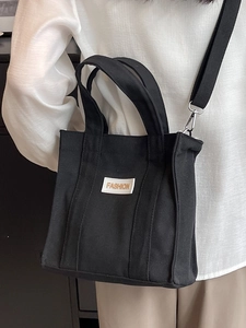 Fashionable black canvas handbag for women with adjustable strap and FASHION logo detail