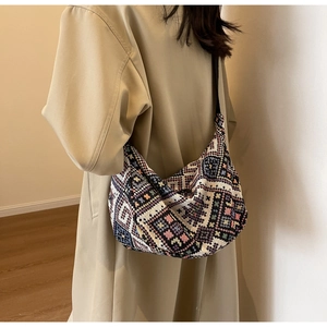 Detailed macro view of bohemian geometric woven fabric on a large dumpling crossbody bag