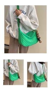 Détail d'un sac matelassé vert vif avec bandoulière réglable et breloque lapin