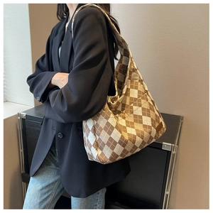 Brown and white argyle canvas tote bag worn by model in casual oversized suit
