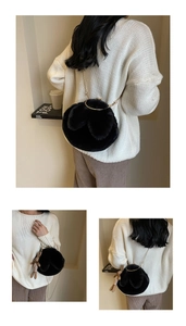 Detail of black fluffy faux fur bag with gold chain strap and cute plush charm