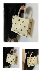Detail view of large canvas tote bag featuring stylish letter print and rope handles