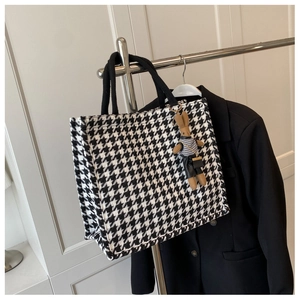 Detail of large tote bag with black and white houndstooth pattern and a cute rabbit charm