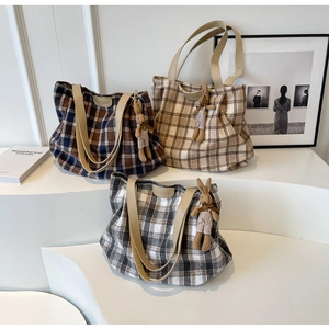 Three large wool tote bags with checkered patterns and cute rabbit charms on a white stand