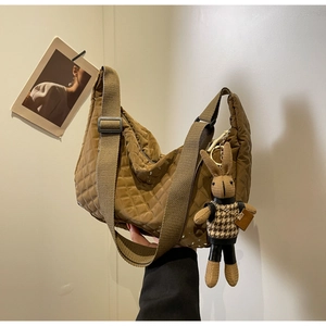 Détail du sac à main matelassé marron en nylon brillant avec pendentif lapin mignon