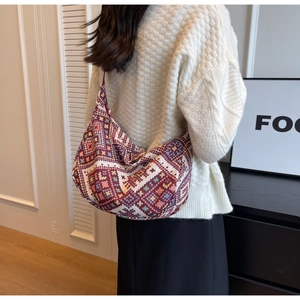 Detail showing the geometric woven texture and rich ethnic patterns of the large shoulder bag