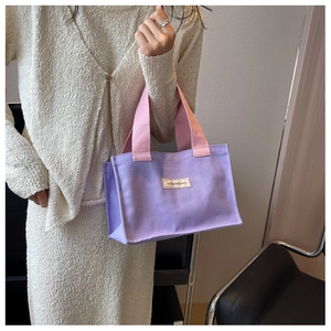 Détail du sac cabas en toile violette avec anses roses et étiquette tissée FASHIONS BAG