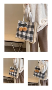 Close-up of black and white checkerboard tote bag with cherry plush charm and woven handle