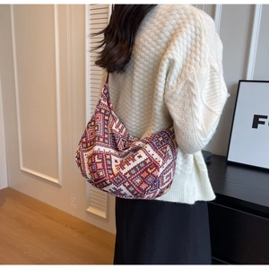 Detail view of ethnic knit hobo bag with geometric diamond patterns and rich textures