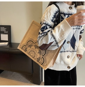 Detailed view of jute tote bag featuring a black mandala print and shoulder strap