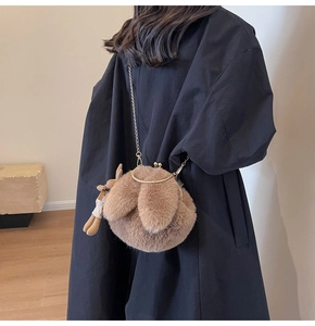 Detail of soft brown plush bunny bag with long ears and golden metal chain strap