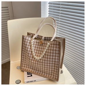 Detail of linen tote bag featuring houndstooth pattern and elegant faux pearl strap