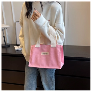 Sac cabas en toile rose avec poignées blanc cassé porté par un mannequin