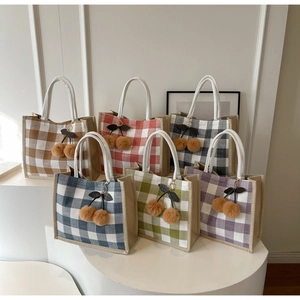 Detail of multi-color linen tote bags with cherry charms and white round handles