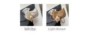 Détail de sacs bandoulière demi-lune avec broderie papillon et breloques monstre en peluche