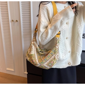 Detail of colorful bohemian woven crossbody bag with a bright yellow shoulder strap