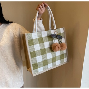 Detail of green and white plaid linen tote bag with brown pompom cherry pendant charm