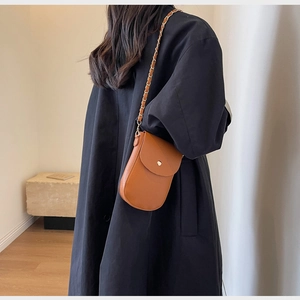Braune Handy-Umhängetasche aus Leder am Modell zur Darstellung von Größe und Stil