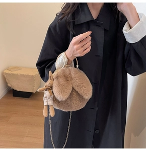 Detail of plush rabbit-shaped crossbody bag with gold metal handle and chain strap