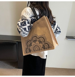 Detailed back view of a large linen tote bag with black floral mandala print and handles