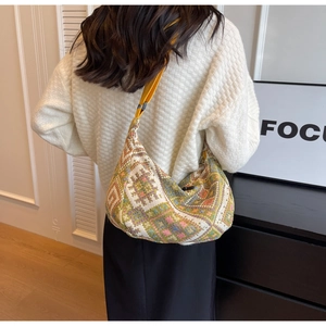 Detail of colorful ethnic woven hobo bag with adjustable bright yellow shoulder strap