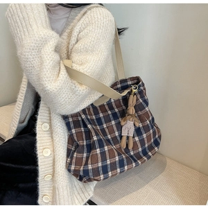 Detail of large wool tote bag with plaid pattern, fashion strap and rabbit charm
