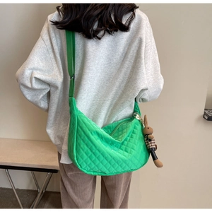 Détail du sac bandoulière matelassé vert avec pendentif lapin et sangle en tissu