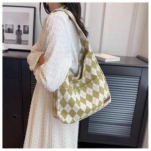 Close-up of a large canvas shoulder bag featuring green and white checkered pattern