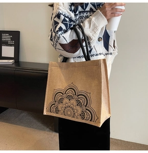 Close-up of linen tote bag with black mandala floral print and round rope handles