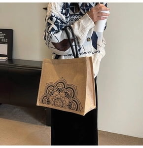 Detailed side view of linen tote bag featuring black mandala pattern and rope handles