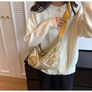 Detail of ethnic geometric woven crossbody bag with colorful patterns and yellow strap