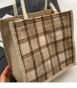 Detail of checkered canvas tote bag showing textured weave and braided rope handles